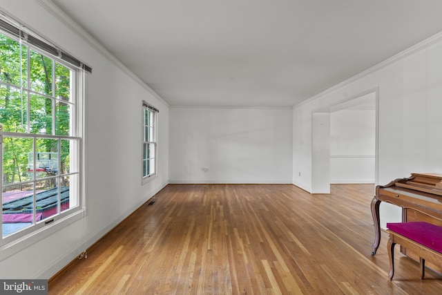 unfurnished room featuring ornamental molding, hardwood / wood-style flooring, and baseboards