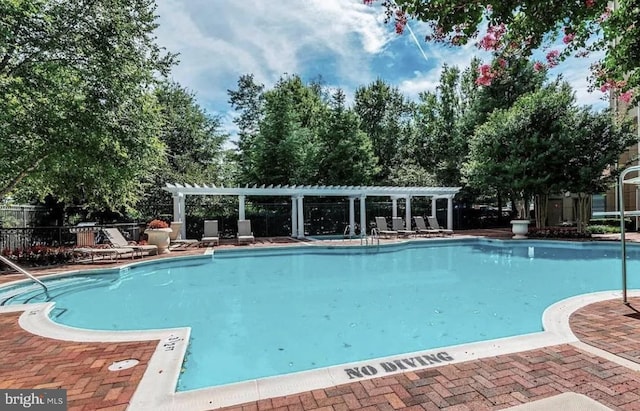 community pool with a patio, a pergola, and fence