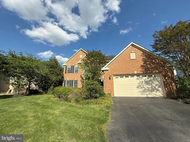 traditional home featuring brick siding, a front lawn, and aphalt driveway