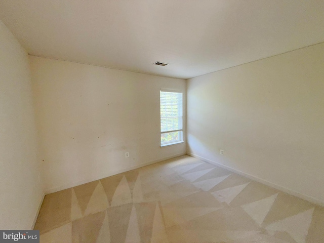 spare room with baseboards and visible vents