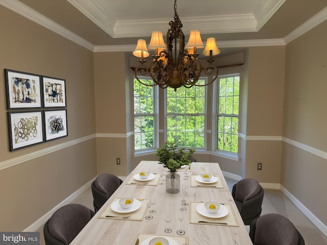 dining room with baseboards, a healthy amount of sunlight, a chandelier, and a tray ceiling