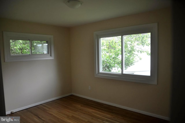 empty room with baseboards and wood finished floors