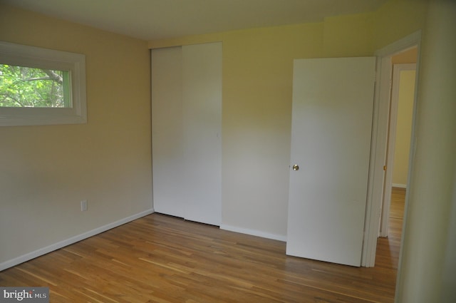 spare room featuring wood finished floors and baseboards