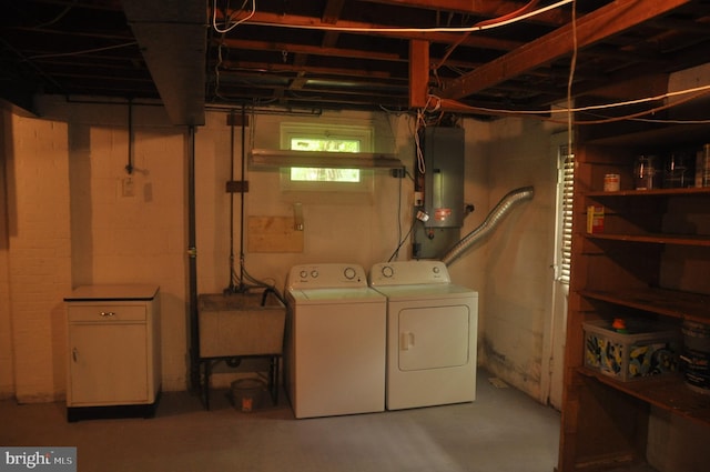 basement featuring separate washer and dryer, electric panel, and a sink