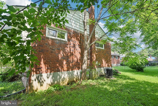 Dauphine St, Silver Spring, MD 20906 - view of side of home with brick siding, a lawn, cooling unit, and a chimney