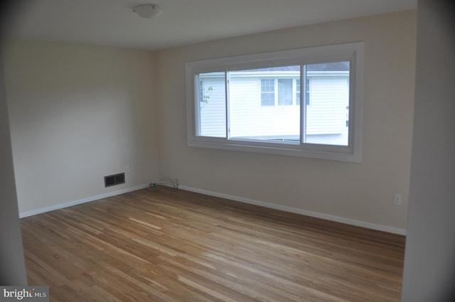 spare room featuring light wood-style floors and baseboards