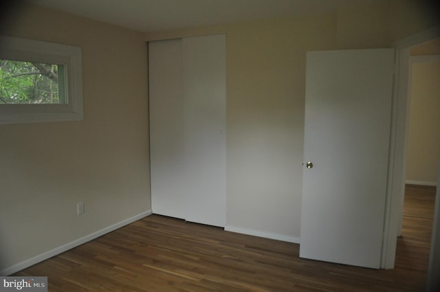 unfurnished room with dark wood-style floors and baseboards