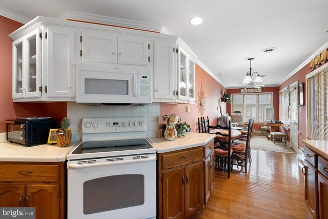 87 Ash Rd, Manahawkin, NJ 08050 - kitchen with white appliances, a chandelier, ornamental molding, light wood-style flooring, and white cabinetry