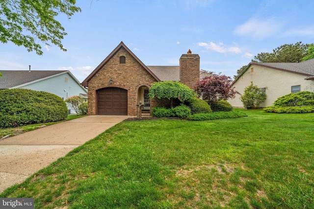 87 Ash Rd, Manahawkin, NJ 08050 - tudor house featuring a chimney, brick siding, an attached garage, a front yard, and driveway