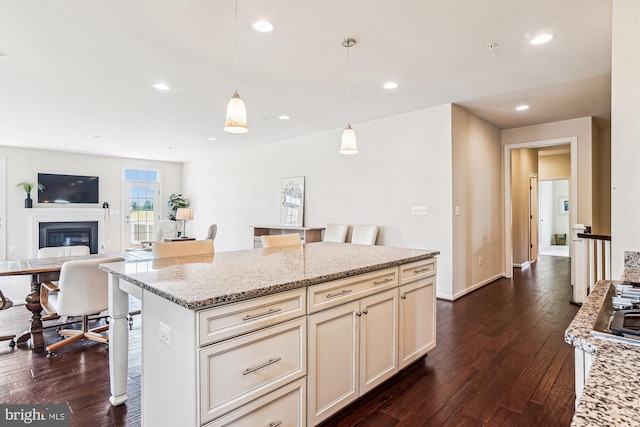 10809 Glowing Hearth Way, Monrovia, MD 21770 - kitchen with dark wood-type flooring, pendant lighting, a breakfast bar, light stone countertops, and cream cabinetry