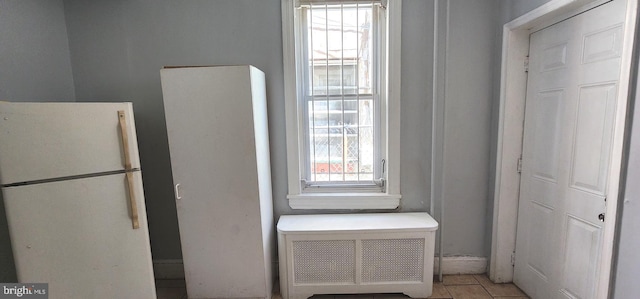 detailed view of freestanding refrigerator and radiator