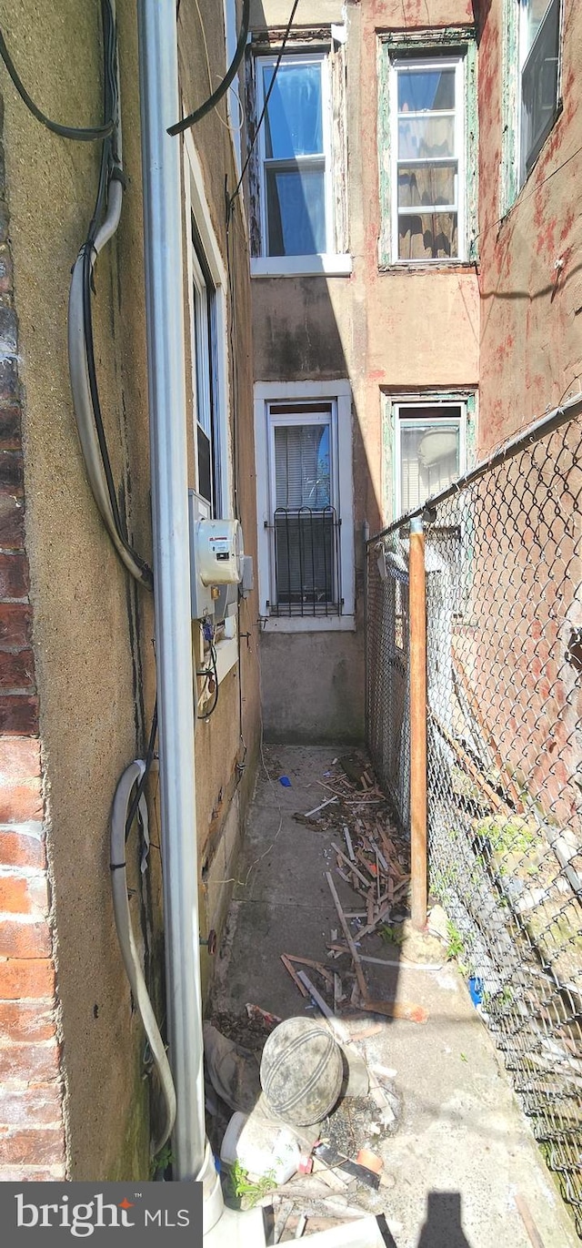 view of side of home featuring fence and stucco siding
