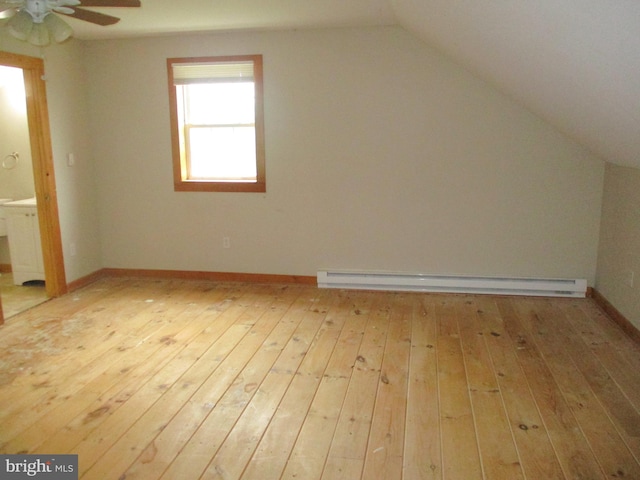 additional living space featuring lofted ceiling, hardwood / wood-style floors, a ceiling fan, baseboard heating, and baseboards