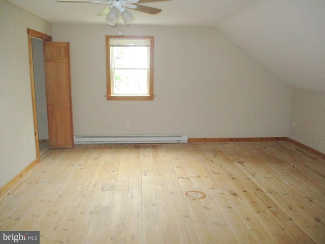 additional living space with vaulted ceiling, a baseboard radiator, ceiling fan, light wood finished floors, and baseboards