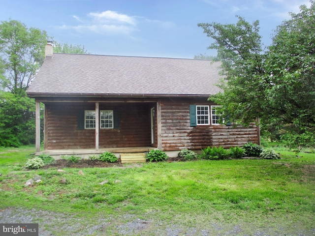 view of front of home featuring a shingled roof, a porch, a chimney, and a front lawn