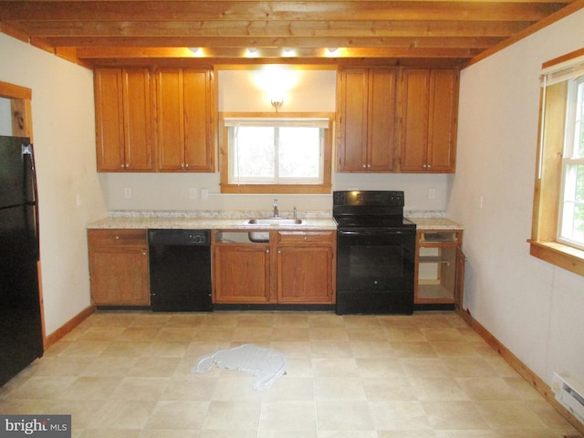 kitchen featuring a sink, brown cabinets, black appliances, beamed ceiling, and light countertops