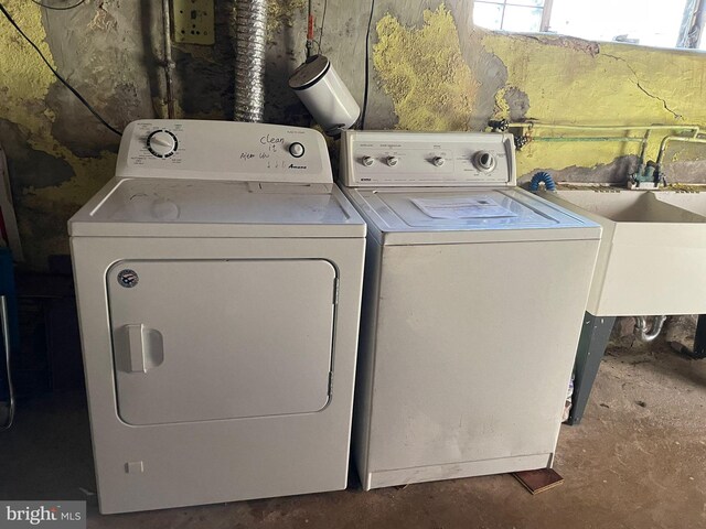 washroom featuring washing machine and dryer, laundry area, and a sink