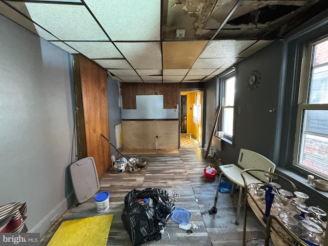 misc room featuring baseboards and a drop ceiling