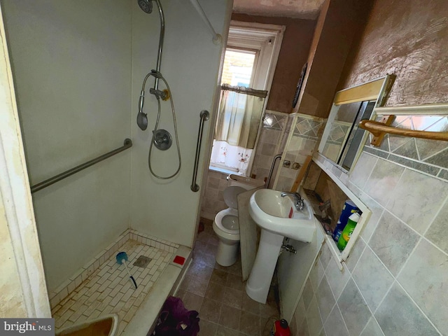 full bath featuring a stall shower, tile walls, tile patterned flooring, toilet, and a wainscoted wall