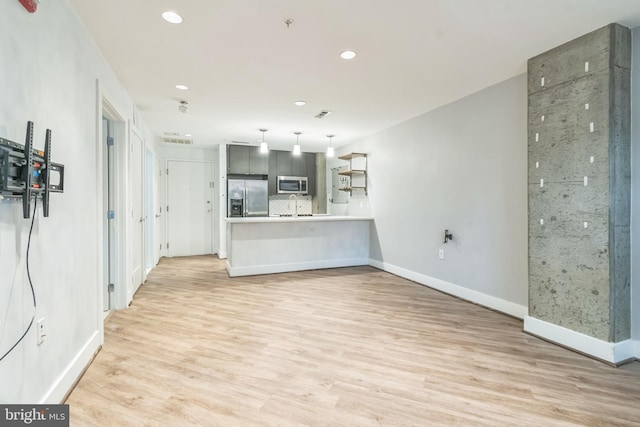 unfurnished living room featuring light wood-type flooring, visible vents, baseboards, and recessed lighting