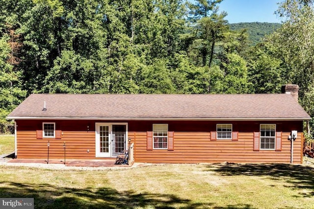back of property with french doors, a patio area, and a yard