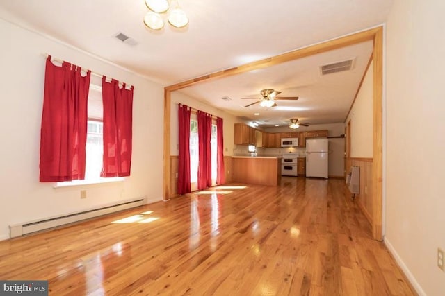 unfurnished living room with a baseboard radiator, light wood finished floors, ceiling fan, and wainscoting