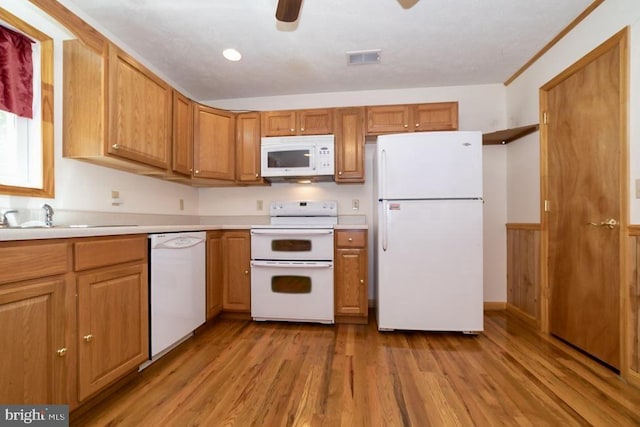 kitchen featuring white appliances, light countertops, light wood-type flooring, a sink, and ceiling fan