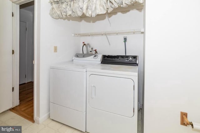 laundry room with independent washer and dryer and baseboards