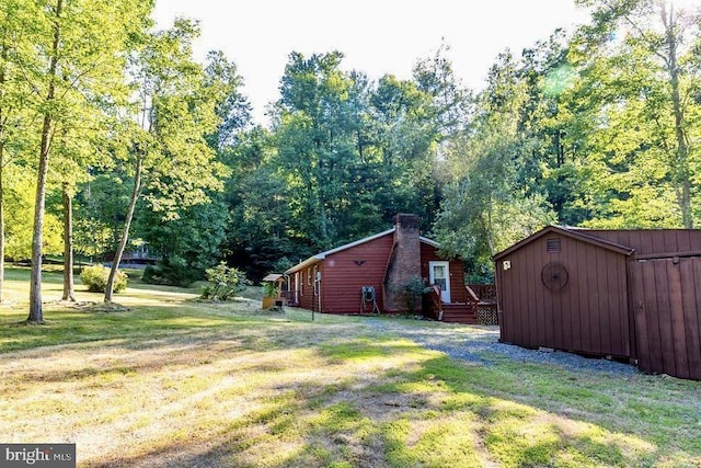 view of green lawn featuring an outdoor structure and a wooden deck