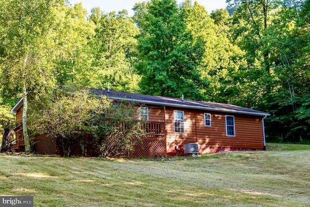 back of house featuring a yard and a wooded view