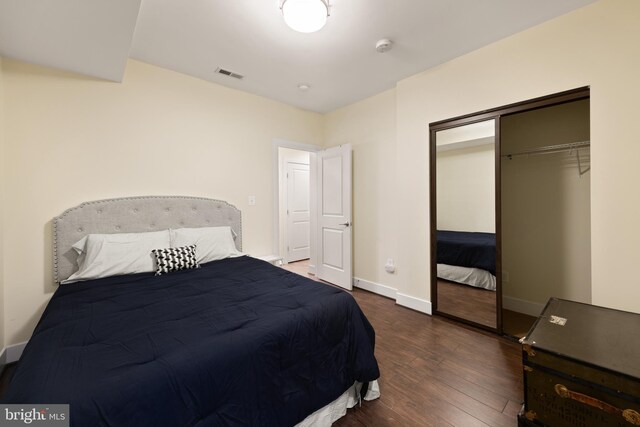 bedroom featuring dark wood-type flooring, a closet, and baseboards