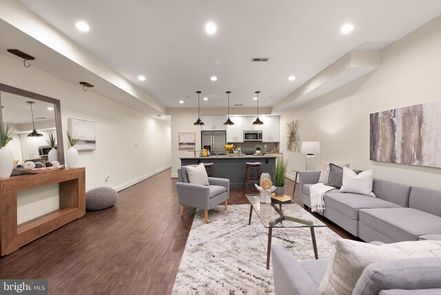 living area featuring recessed lighting, dark wood finished floors, and baseboards