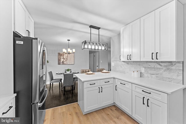 7606 Millrace Rd, Capitol Heights, MD 20743 - kitchen with stainless steel refrigerator with ice dispenser, white cabinetry, light wood-style floors, a peninsula, and backsplash