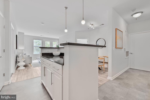 1201 E E W Hwy Unit 208, Silver Spring, MD 20910 - kitchen featuring dark countertops, white cabinetry, decorative light fixtures, baseboards, and a kitchen island