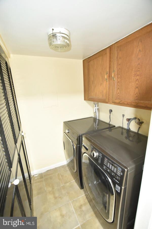3171 Chester Grove Rd, Upper Marlboro, MD 20774 - laundry room with cabinet space, washer and dryer, baseboards, and light tile patterned floors