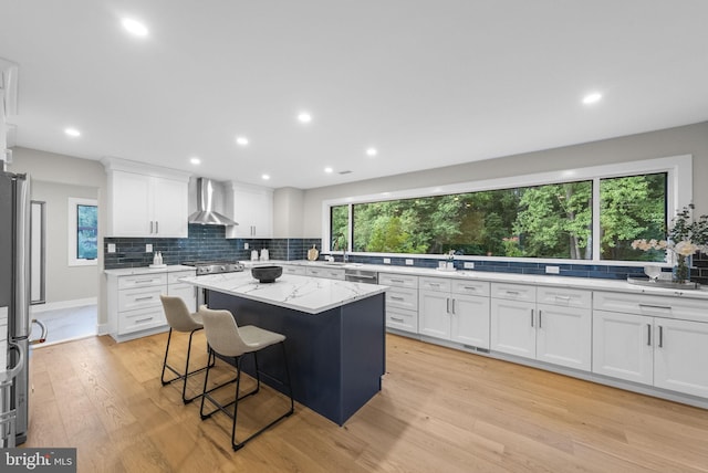 18 Haskel Dr, West Windsor, NJ 08550 - kitchen with wall chimney range hood, decorative backsplash, white cabinetry, light wood-style flooring, and a center island