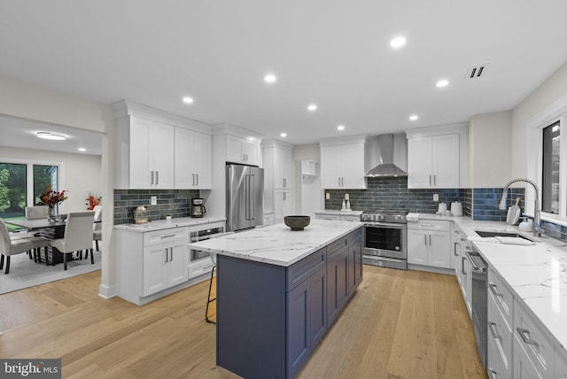 18 Haskel Dr, West Windsor, NJ 08550 - kitchen featuring appliances with stainless steel finishes, wall chimney range hood, white cabinetry, a center island, and recessed lighting