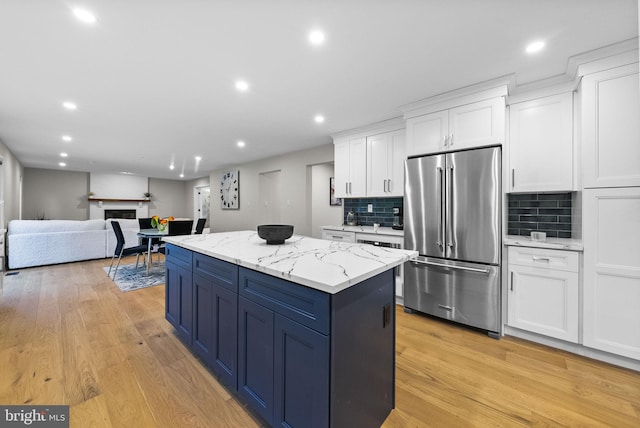 18 Haskel Dr, West Windsor, NJ 08550 - kitchen with high end fridge, white cabinetry, light wood-type flooring, a kitchen island, and decorative backsplash