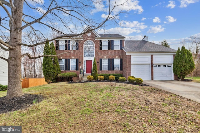 colonial inspired home with brick siding, concrete driveway, and a garage