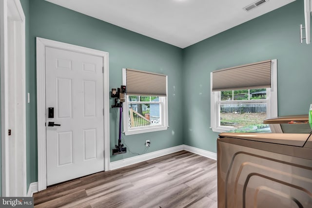 entrance foyer with wood finished floors, baseboards, and washer and dryer
