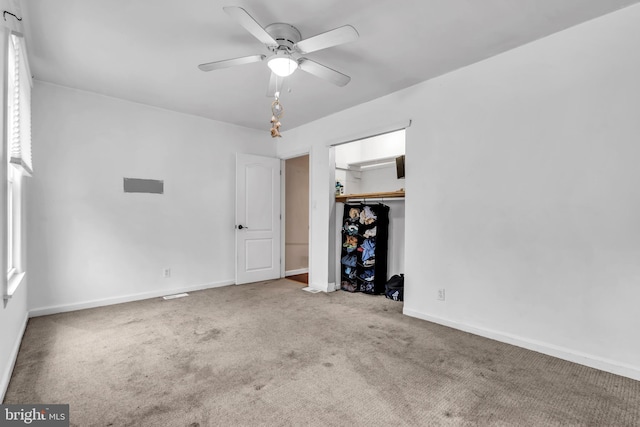 unfurnished bedroom with carpet floors, baseboards, a closet, and a ceiling fan