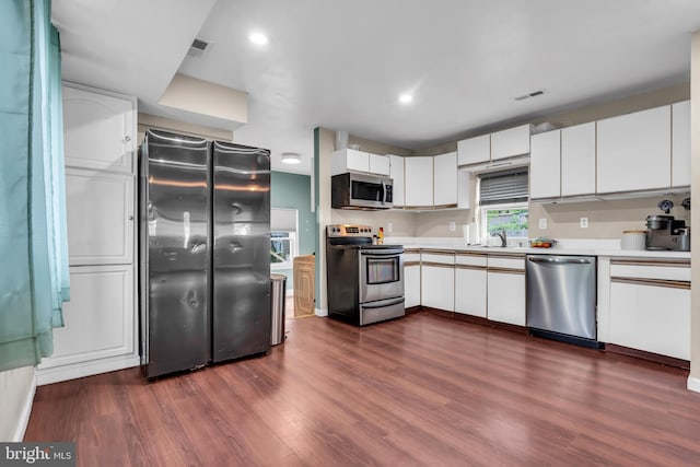 kitchen featuring appliances with stainless steel finishes, light countertops, dark wood-style floors, white cabinetry, and recessed lighting