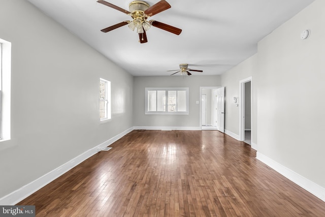 unfurnished living room with ceiling fan, wood-type flooring, and baseboards