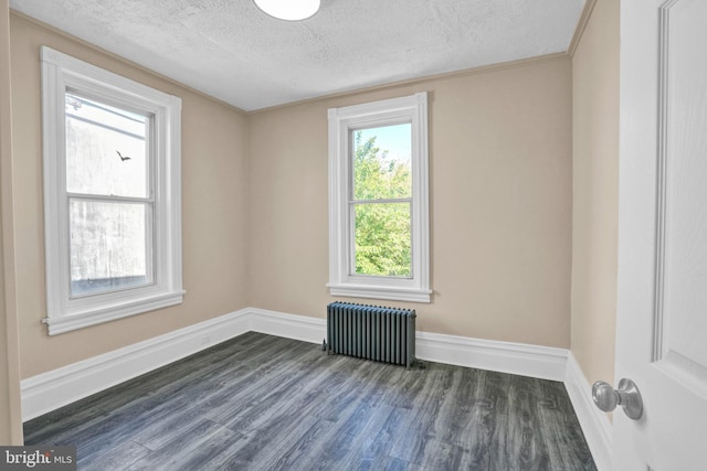 unfurnished room with radiator heating unit, a textured ceiling, dark wood-style flooring, and baseboards