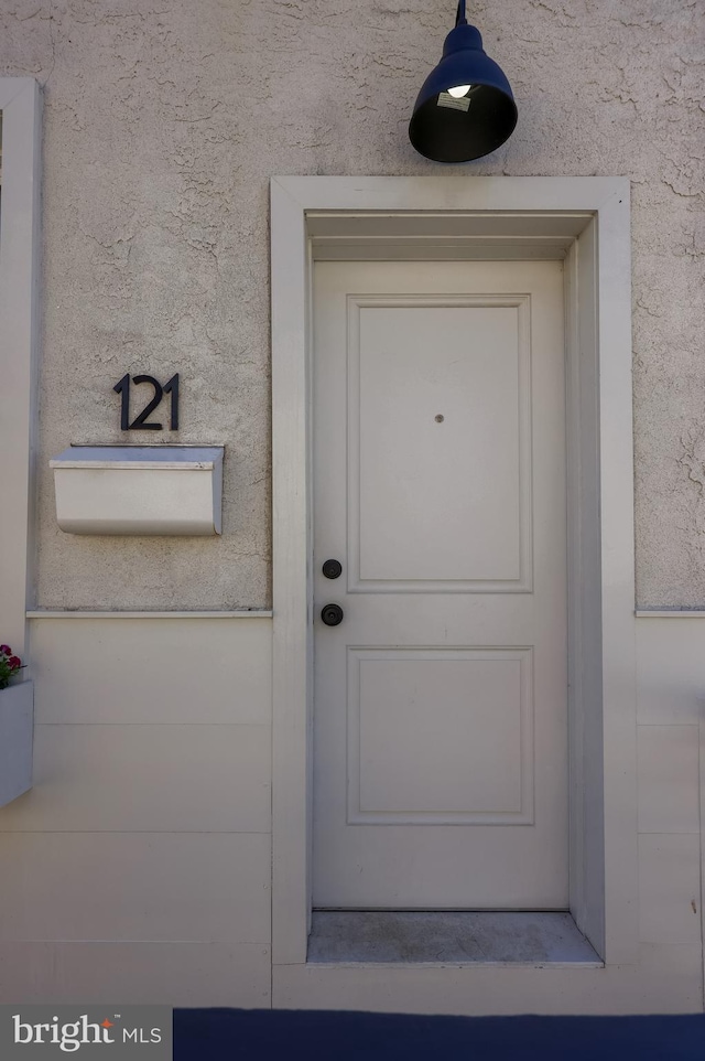 doorway to property featuring stucco siding