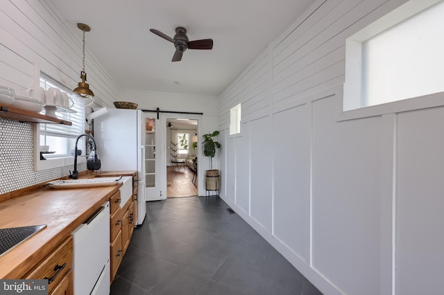 hallway featuring a barn door, a sink, and healthy amount of natural light