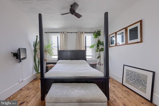 bedroom featuring an ornate ceiling, baseboards, light wood-type flooring, and ceiling fan