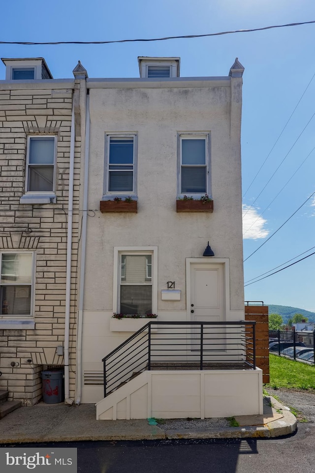 townhome / multi-family property featuring stucco siding and fence