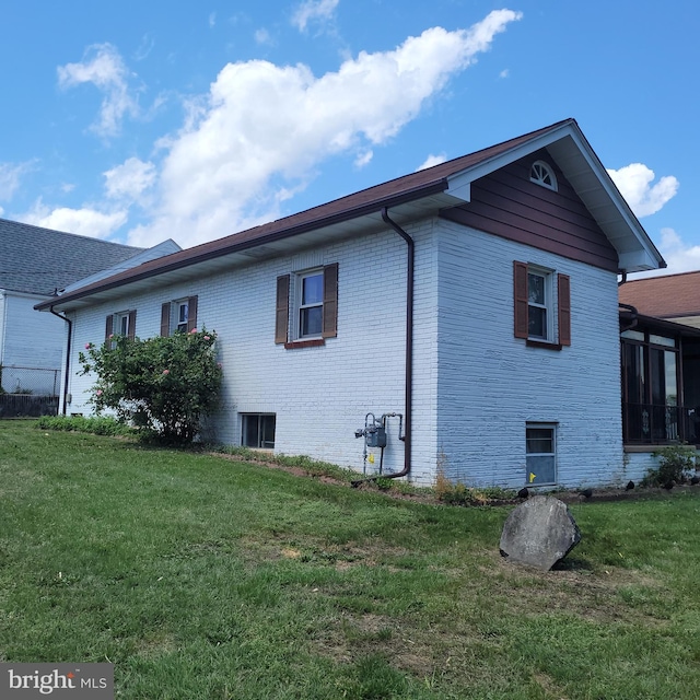 view of side of property with a lawn and brick siding