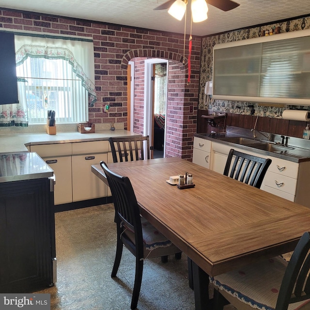 dining space with brick wall and ceiling fan
